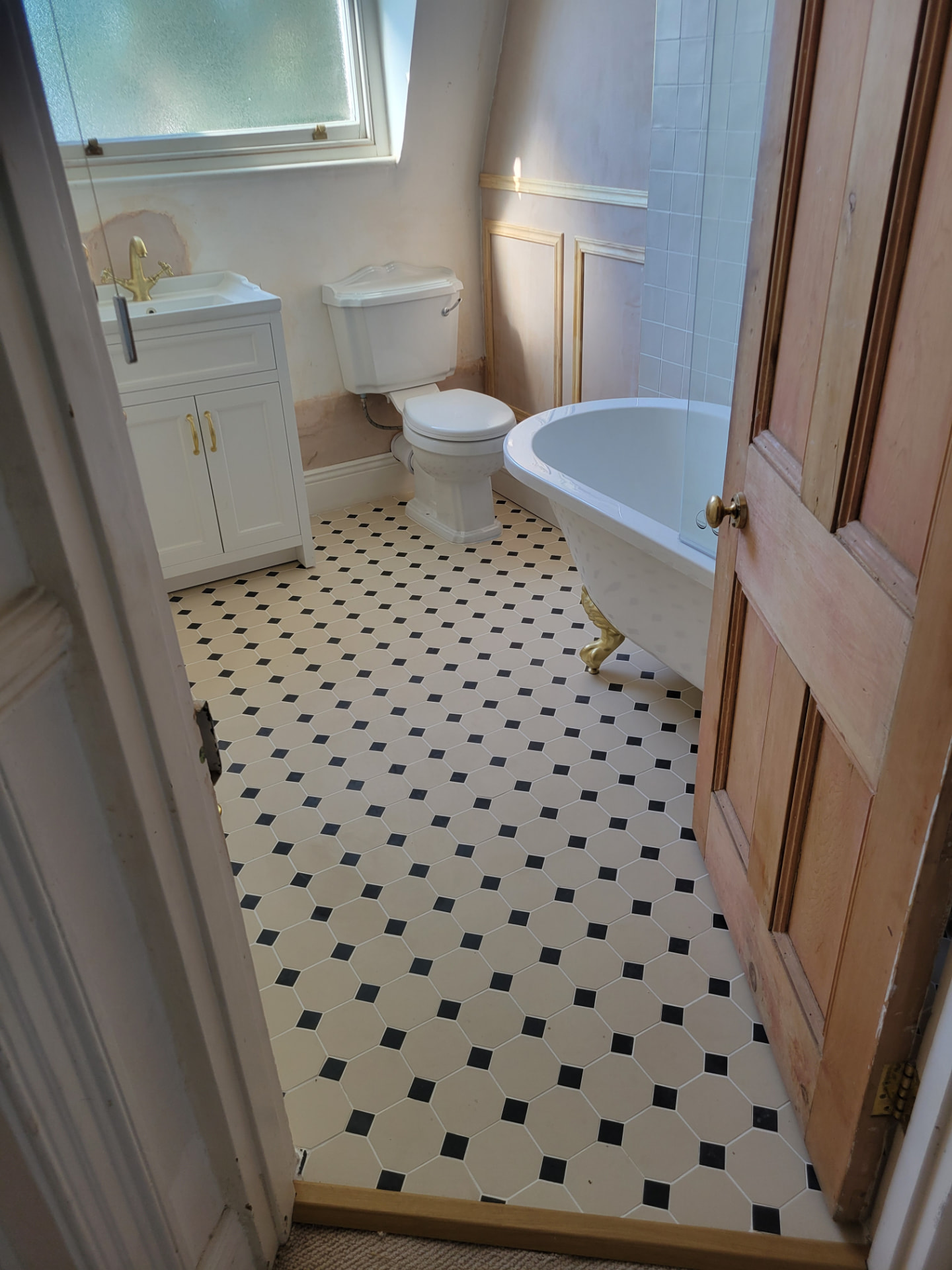 Bathroom viewed from the doorway, with the patterned floor, vanity, WC and bath