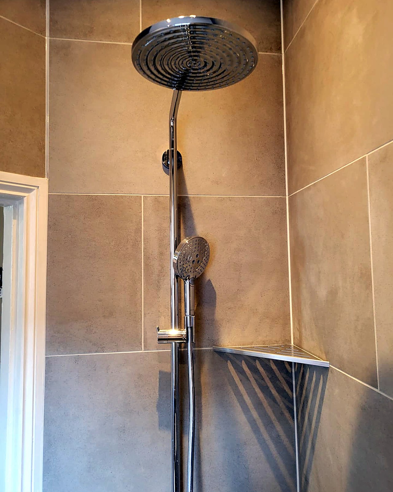 Close-up of the rainfall shower head and corner shelf detail